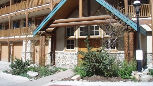 Una cabaña de varios pisos con balcones de madera, detalles de piedra y una estructura de techo sobresaliente.