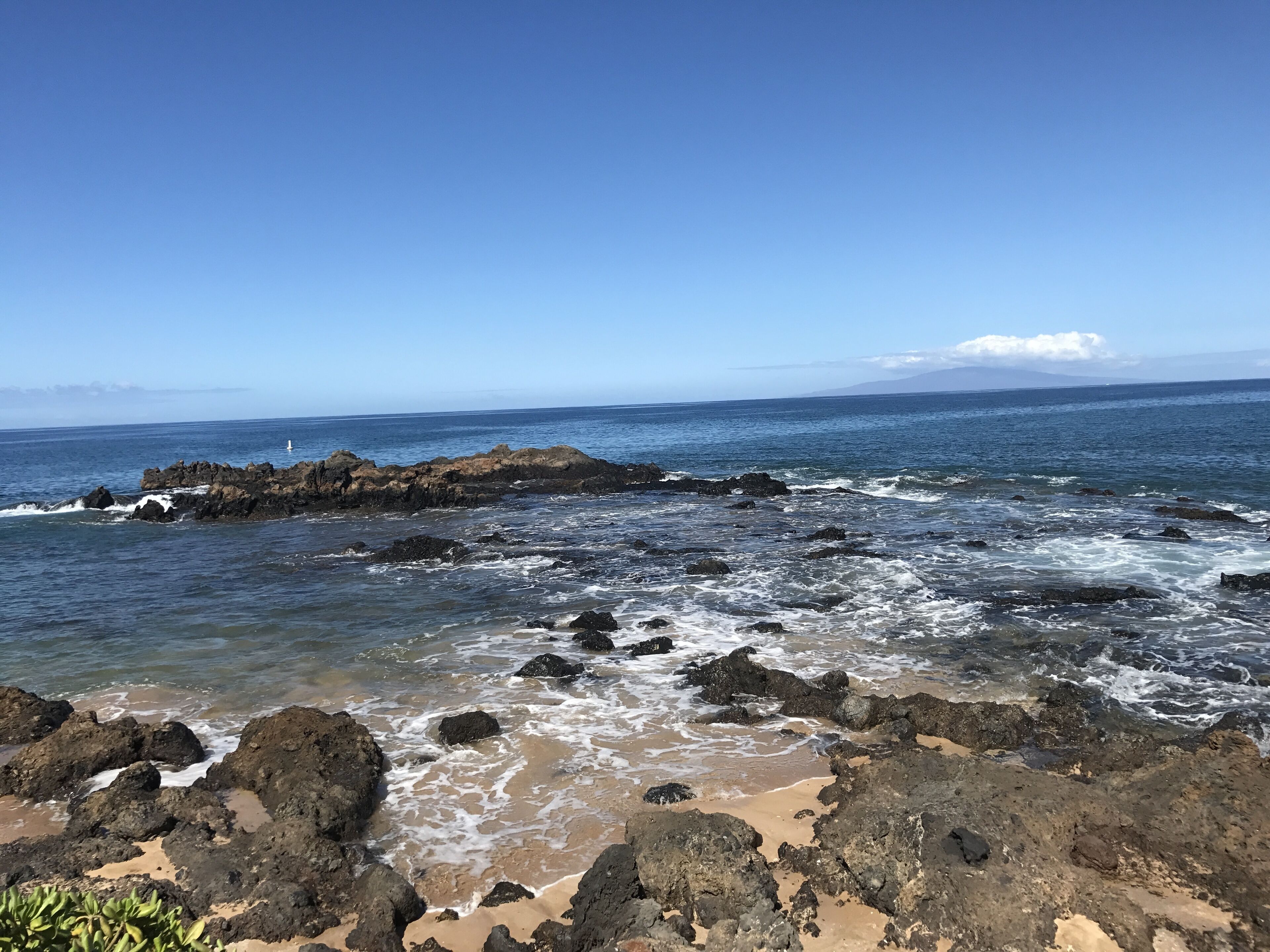Une côte rocheuse où les vagues se brisent sur la plage.