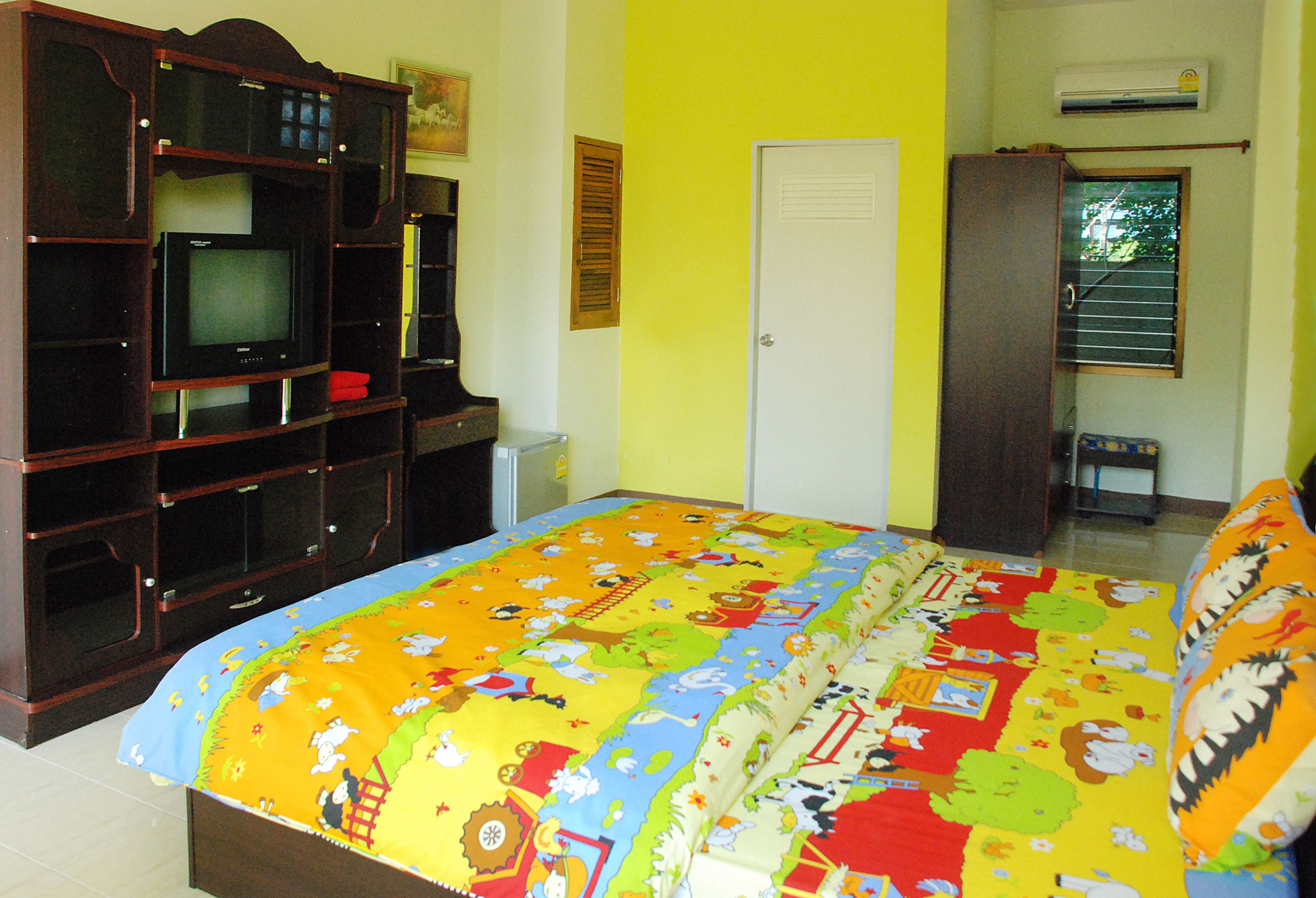 Un dormitorio con cama, televisor, armario y puerta.