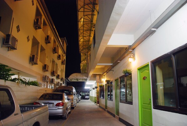Una calle estrecha con coches aparcados y edificios a ambos lados.