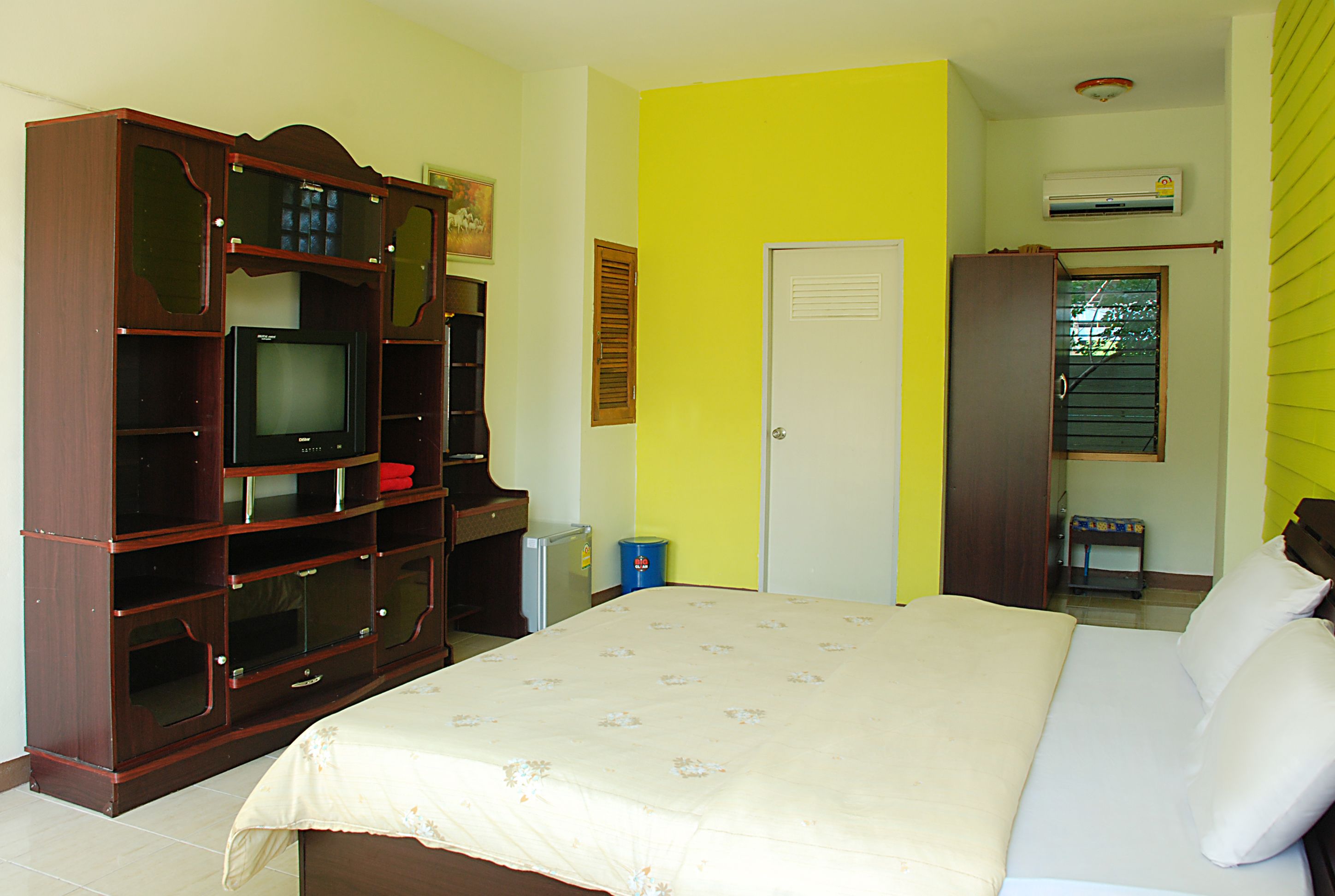 A bedroom with a bed, a television, and a wardrobe.