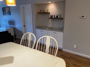Cozy living space with a dining area, kitchenette, and wooden flooring.