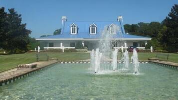 A large building with a blue roof and a fountain in the foreground.