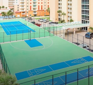 Un complexe sportif à plusieurs niveaux comprenant plusieurs terrains de basket-ball et un pont piétonnier reliant les différents niveaux.