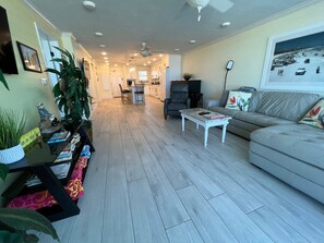 Un salon spacieux avec un canapé de couleur claire, une table basse et un coin repas comprenant des chaises et une table.
