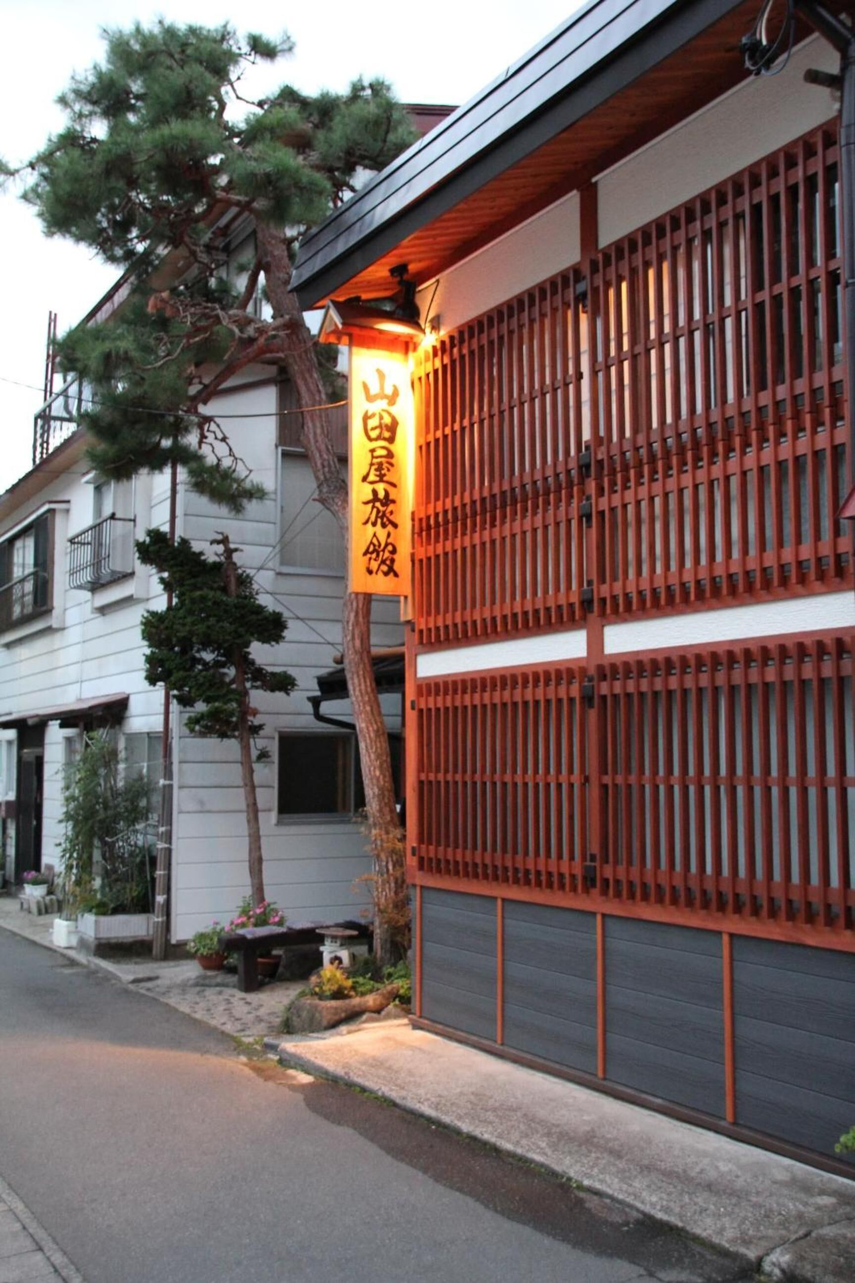 A traditional Japanese building with a wooden fence and a sign.