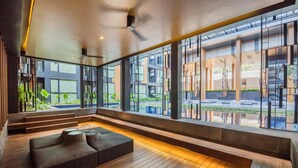 Een modern interieur met een houten vloer, een bank en grote ramen met uitzicht op het omliggende landschap.