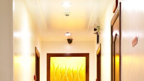 A hallway with a large white vase, a patterned wall, and a door on the right. - Grand Isabella Residences (Cebu City)