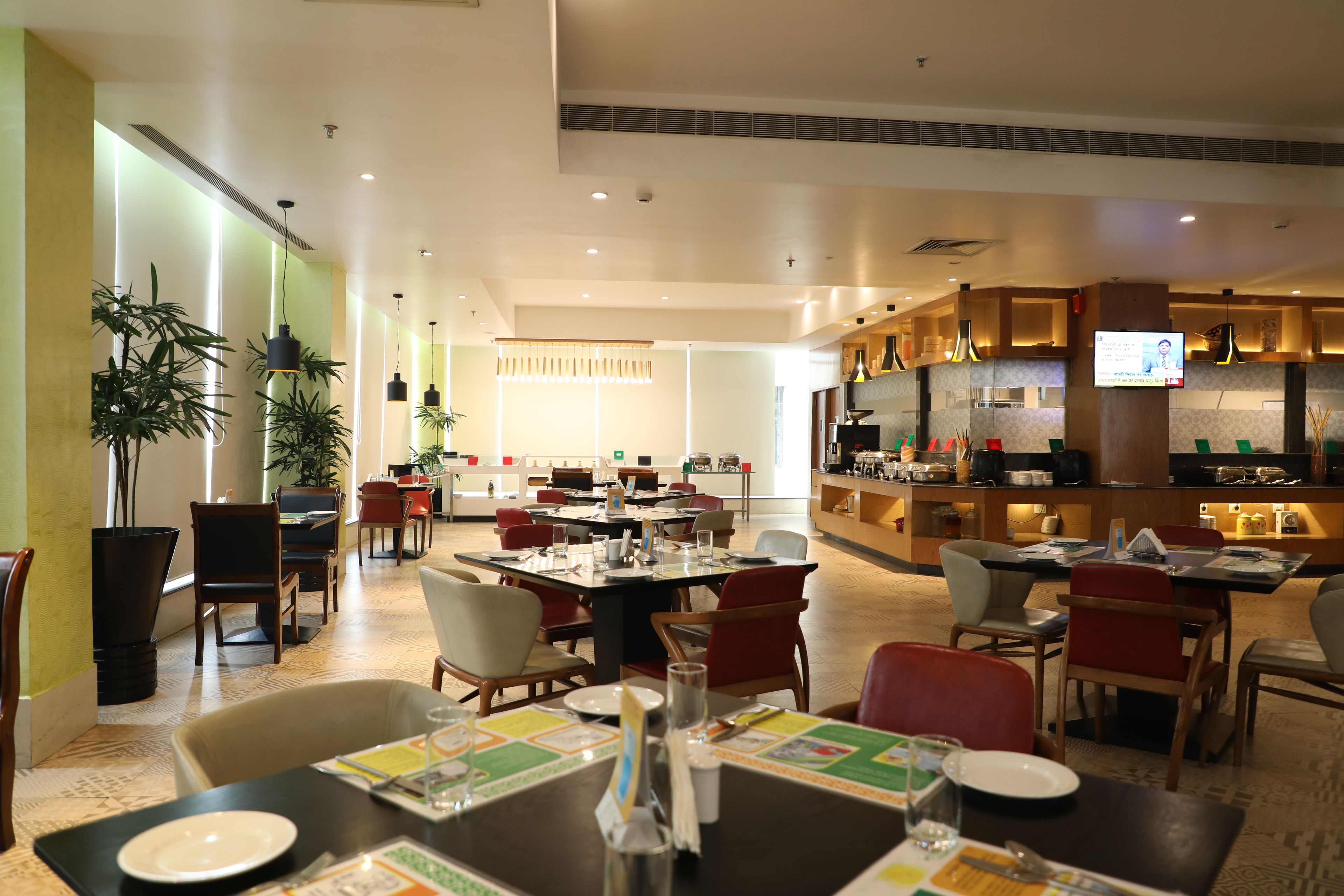 A modern restaurant with multiple dining tables, chairs, and a bar area.