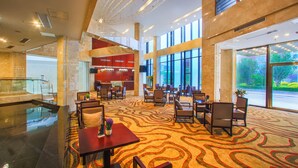 Een hotel lobby met een ruime open ruimte, zitgedeeltes, een receptiebalie en uitzicht op het omliggende landschap.