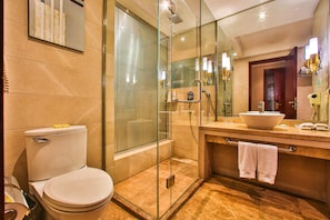 Une salle de bain moderne avec une douche à parois de verre, des toilettes blanches et un meuble-lavabo doté d’un grand miroir et d’un évier.