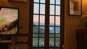 A room with a large arched window, a television, a chair, and two blue vases on the floor. - Welcome to Lucca and beautiful Villa Adriano! (Valdottavo)