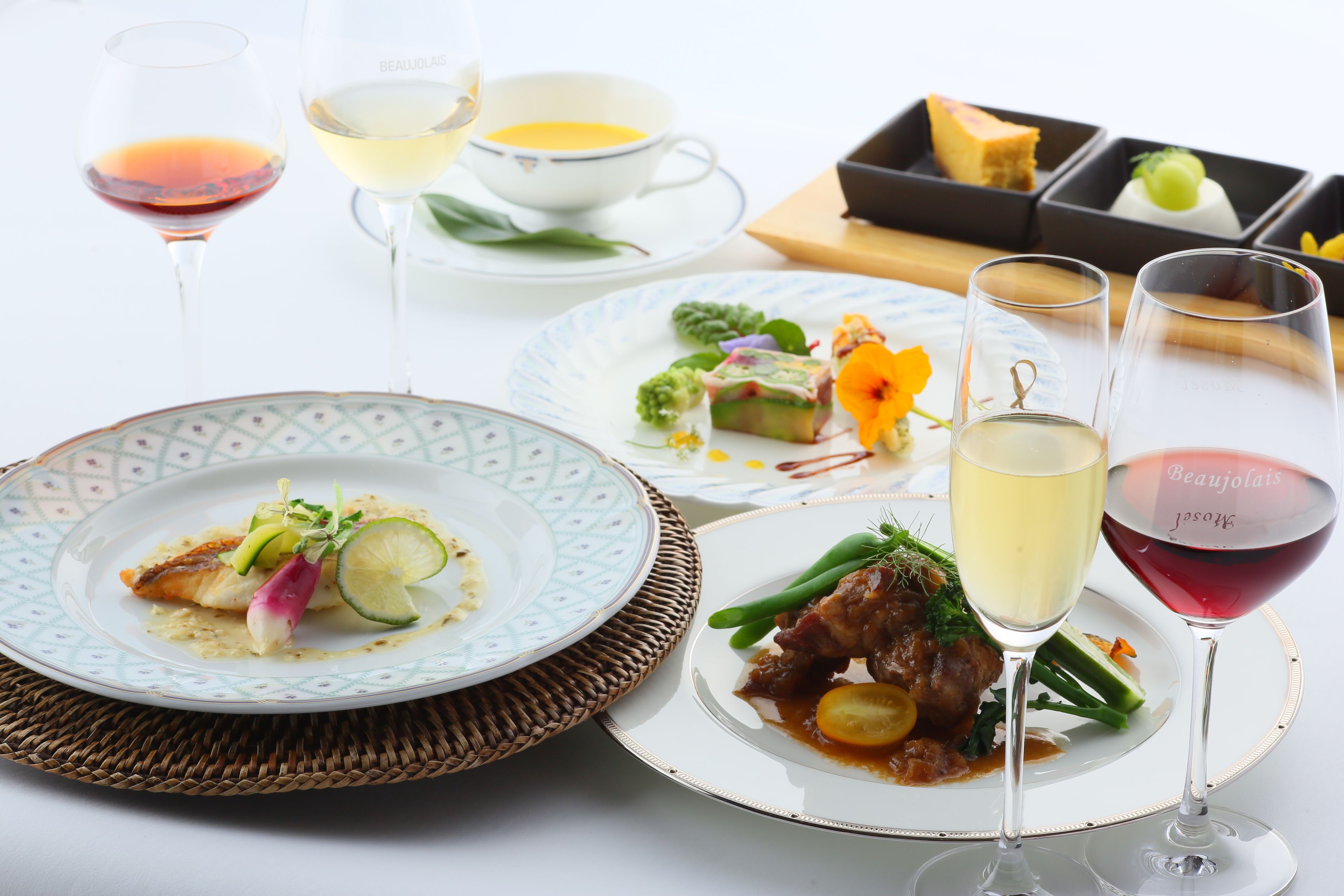 A table set with various dishes and glasses of wine.