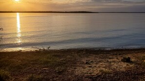 A calm lake at sunset with a clear sky. - Treehouse Cabin/ Beach and Lake Access (Pottsboro)