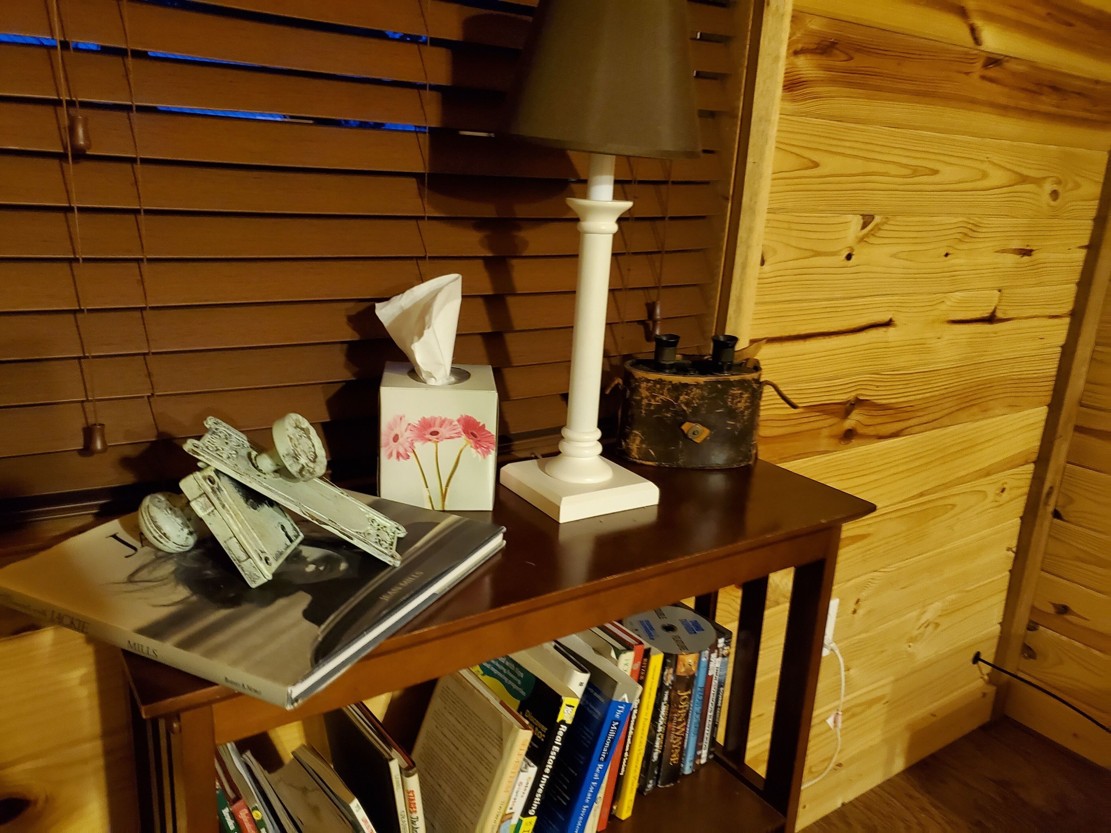 Ein Holztisch mit einer Papiertauschbox, einer Lampe und einem kleinen dekorativen Gegenstand.