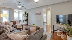 A modern living room with a large sectional sofa, a flat-screen TV, ceiling fans, and a wooden floor. - The Kearney♥Accessibility Features♥Free Parking/W+D/Family Friendly/Ensuites (Nashville)