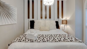 A modern bedroom with a large bed, a chandelier, and a wall-mounted artwork. - The Kearney♥Accessibility Features♥Free Parking/W+D/Family Friendly/Ensuites (Nashville)