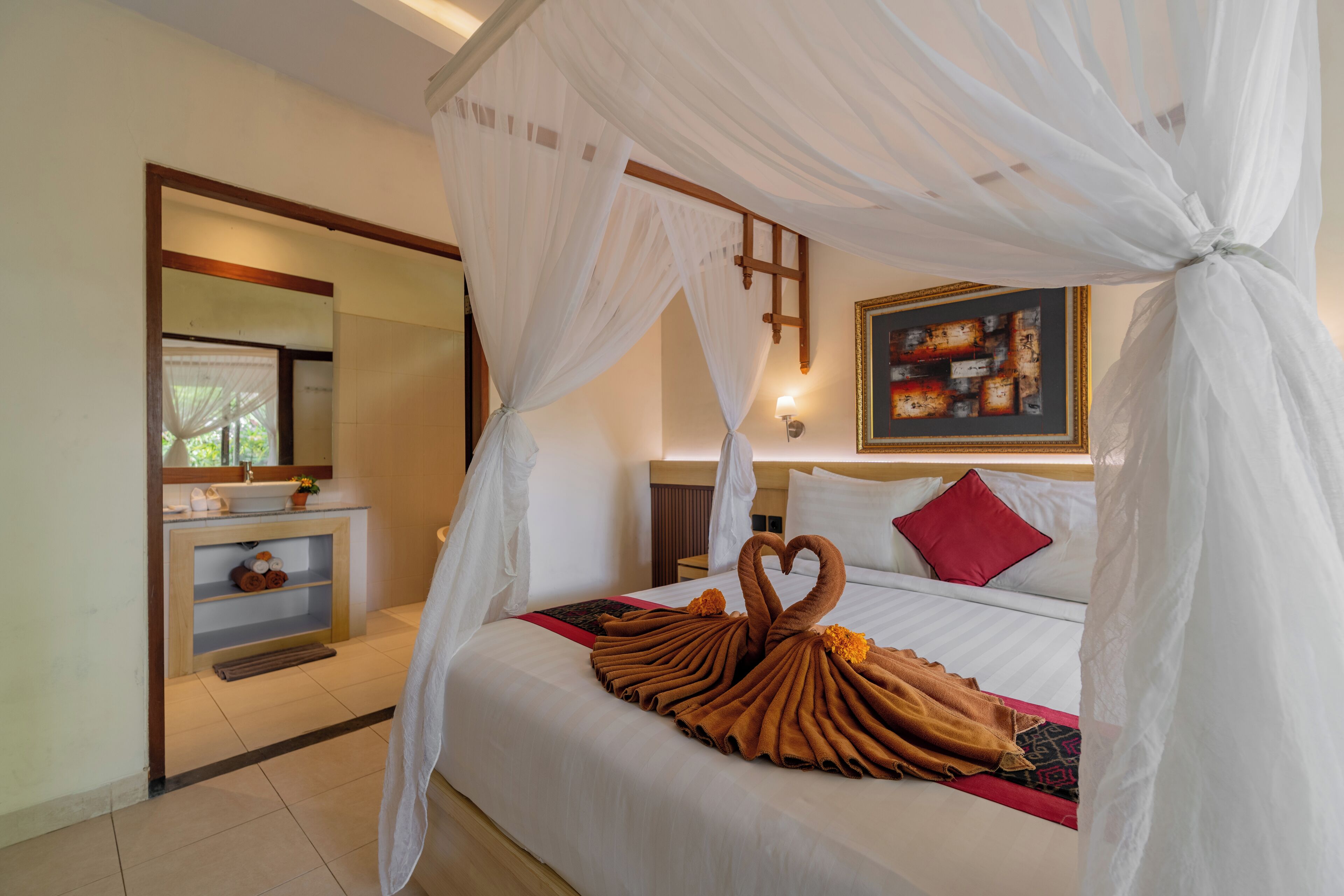 A hotel room with a bed, a bedside table, a mirror, and a painting on the wall.