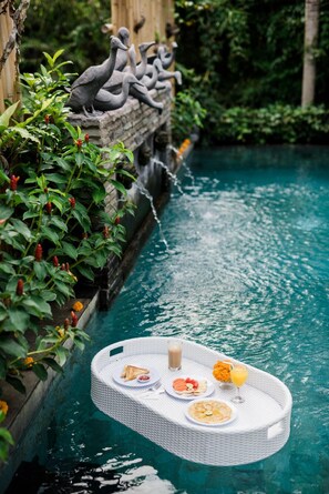 Un plateau flottant avec de la nourriture et des boissons dans une piscine.