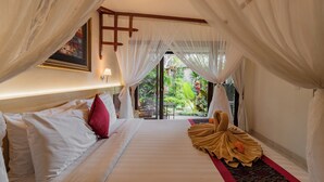 A bedroom with a bed, a red pillow, a white canopy, and a view of the outdoors. - Desak Putu Putra Hidden (Ubud)