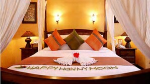 A bed with a floral arrangement and a message on the bedspread. - Greenwood Udawalawa Safari Resort (Udawalawa)