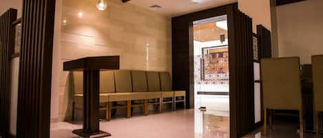 A modern lobby with a reception desk, seating area, and decorative lighting.
