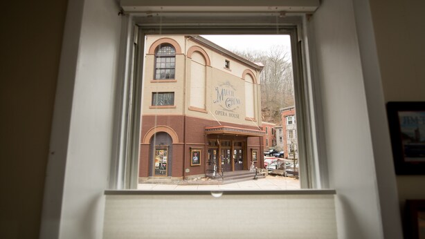 Blick auf die Außenansicht des Malch Chunk Opera House, mit einer klassischen Ziegel-Fassade, bogenförmigen Fenstern und einem markanten Eingang.