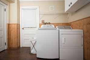 Convenient laundry facilities feature a washer and dryer, a door with a window, and a trash bin.