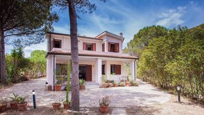 A two-story house with a tiled roof, surrounded by potted plants and trees. - PINE CONE DIRECT ACCESS TO THE BEACH ( NO WIFI ) CIN IT091063C2000S5156 (Cala Liberotto  Sos Alinos  (Orosei))