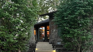 A stone staircase leading to a stone building with a covered entrance.