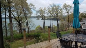 A deck with a table and chairs overlooking a lake with trees and a distant island. - Best Views on Beaver Lake close to Rogers (Rogers)