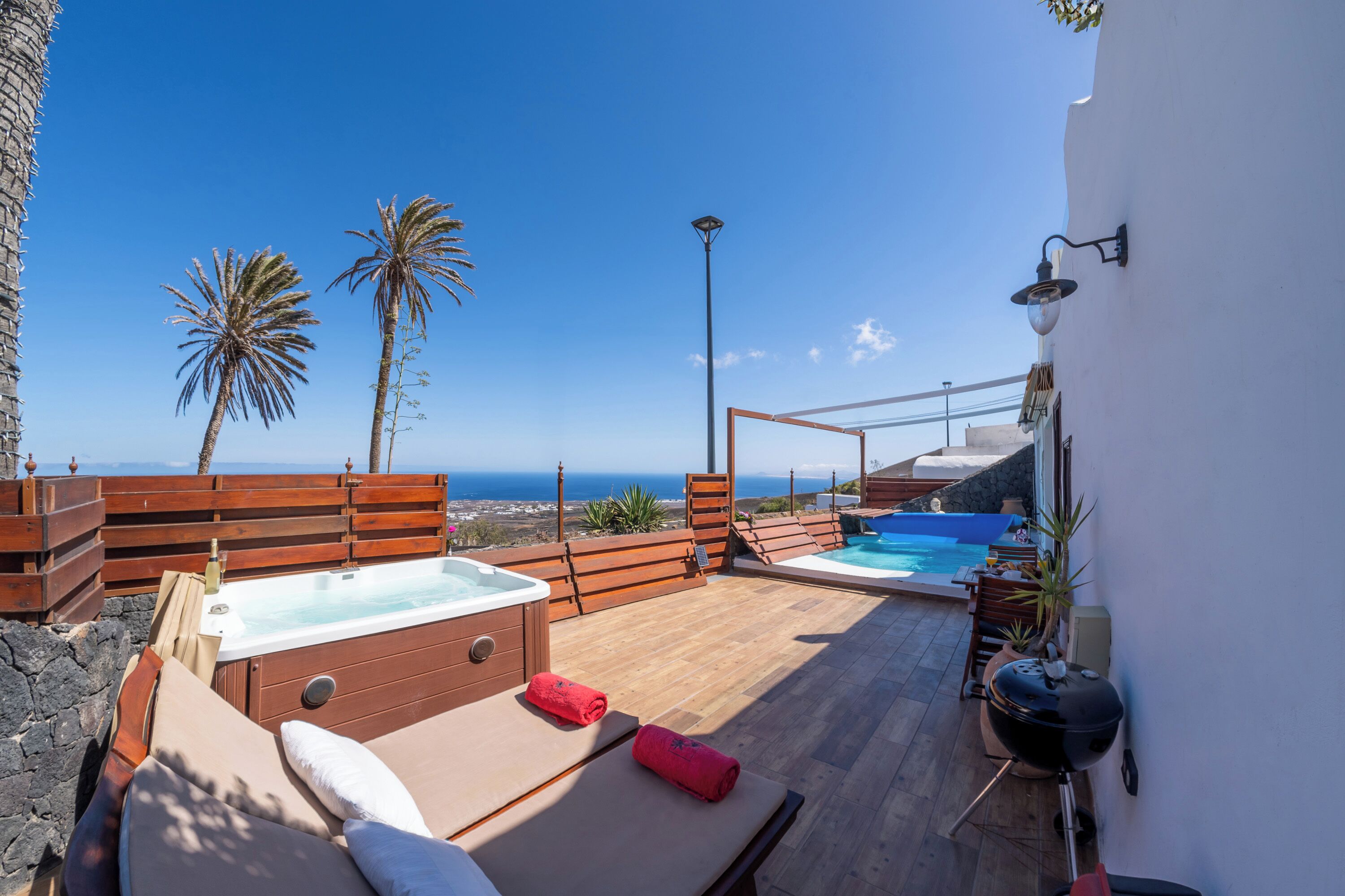 Une terrasse sur le toit avec un jacuzzi, un barbecue et une piscine.