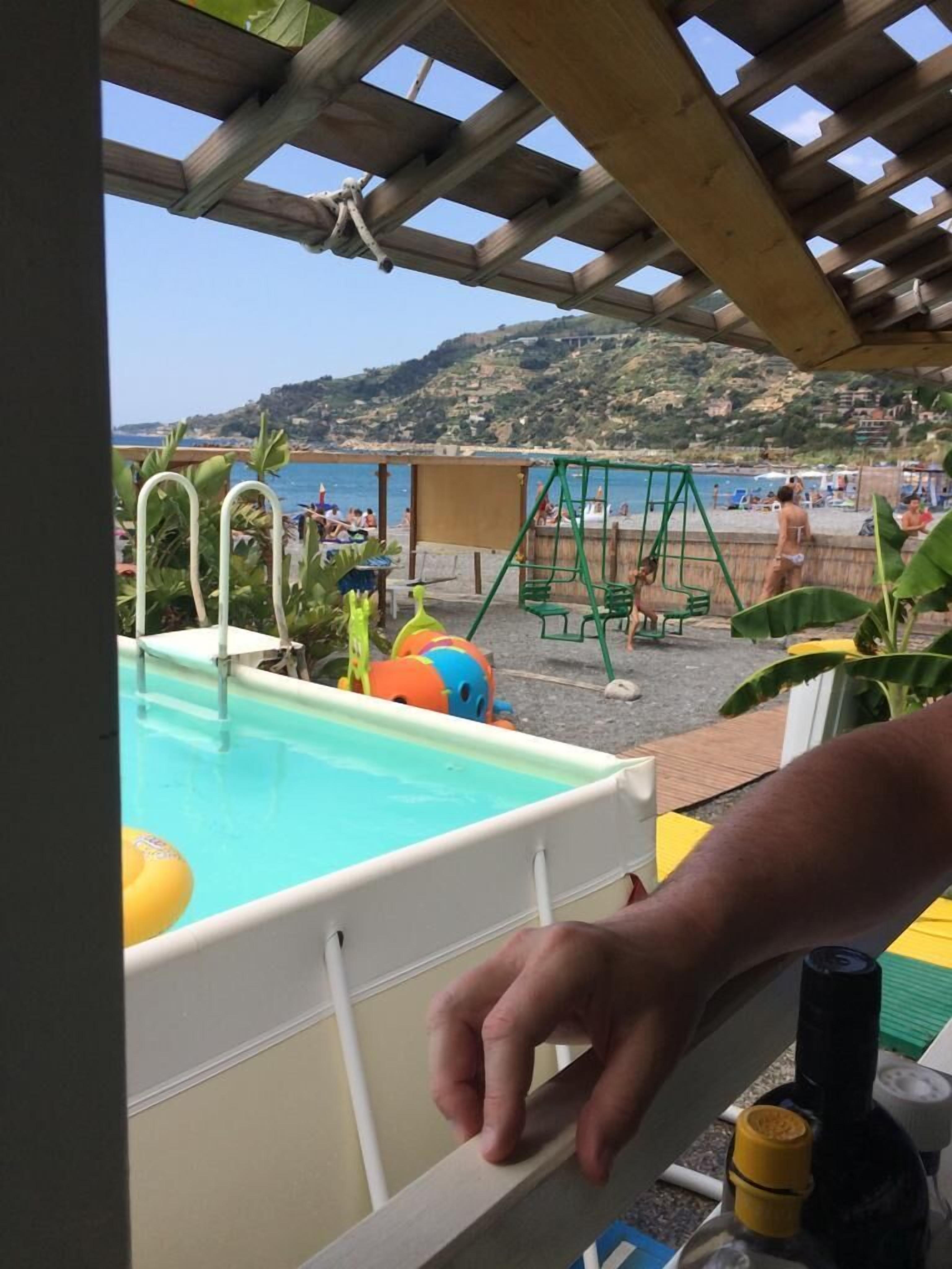 A pool area with a view of the beach and hills.