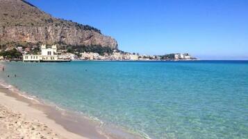 Una playa cerca, sillas reclinables de playa, toallas de playa