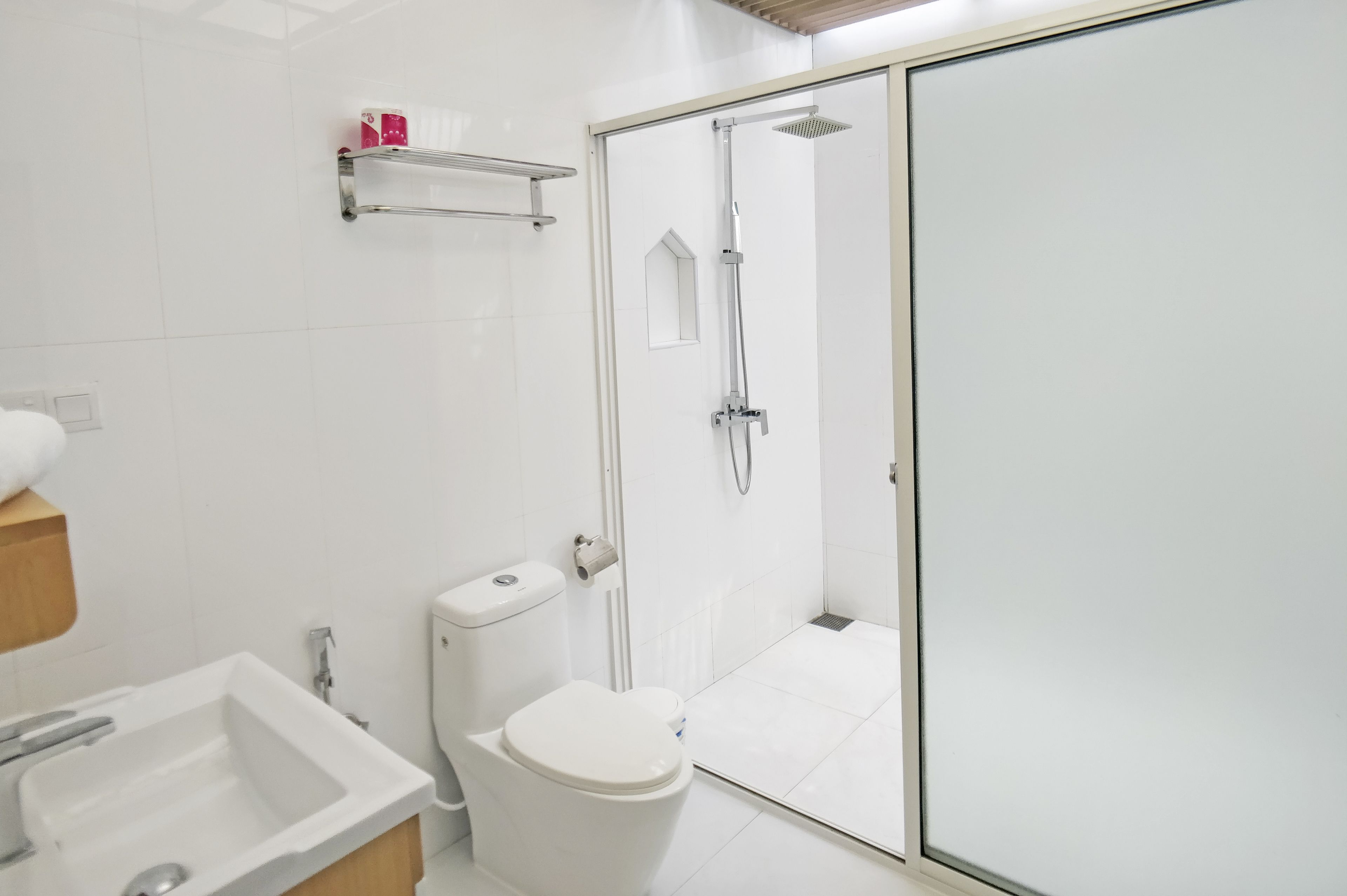 Un baño moderno con ducha envuelta en vidrio, inodoro y lavamanos.