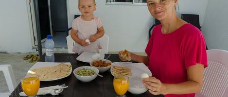 A dining table with food and drinks, a baby, and an adult.