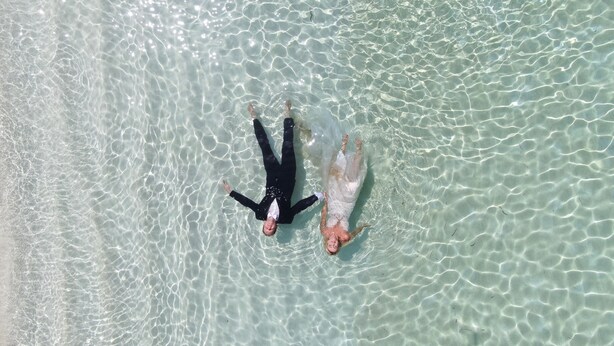 Two people floating on a clear, shallow body of water. - Thoddoo Inn (Thoddoo)