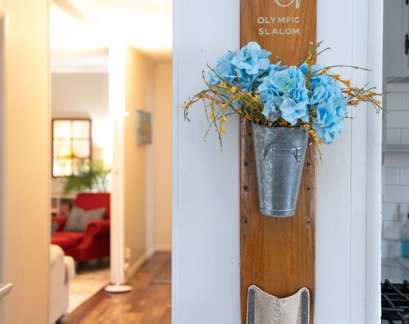 A wooden wall with a metal bucket holding blue flowers and a sign that reads "Olympic Slalom". - The Bay House - 1 block from Geneva Lake (Williams Bay)