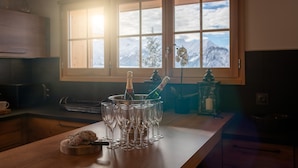 Een keuken met een houten aanrecht, een fles champagne en verschillende glazen.