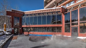 Un edificio con amplios ventanales y una zona exterior cubierta.