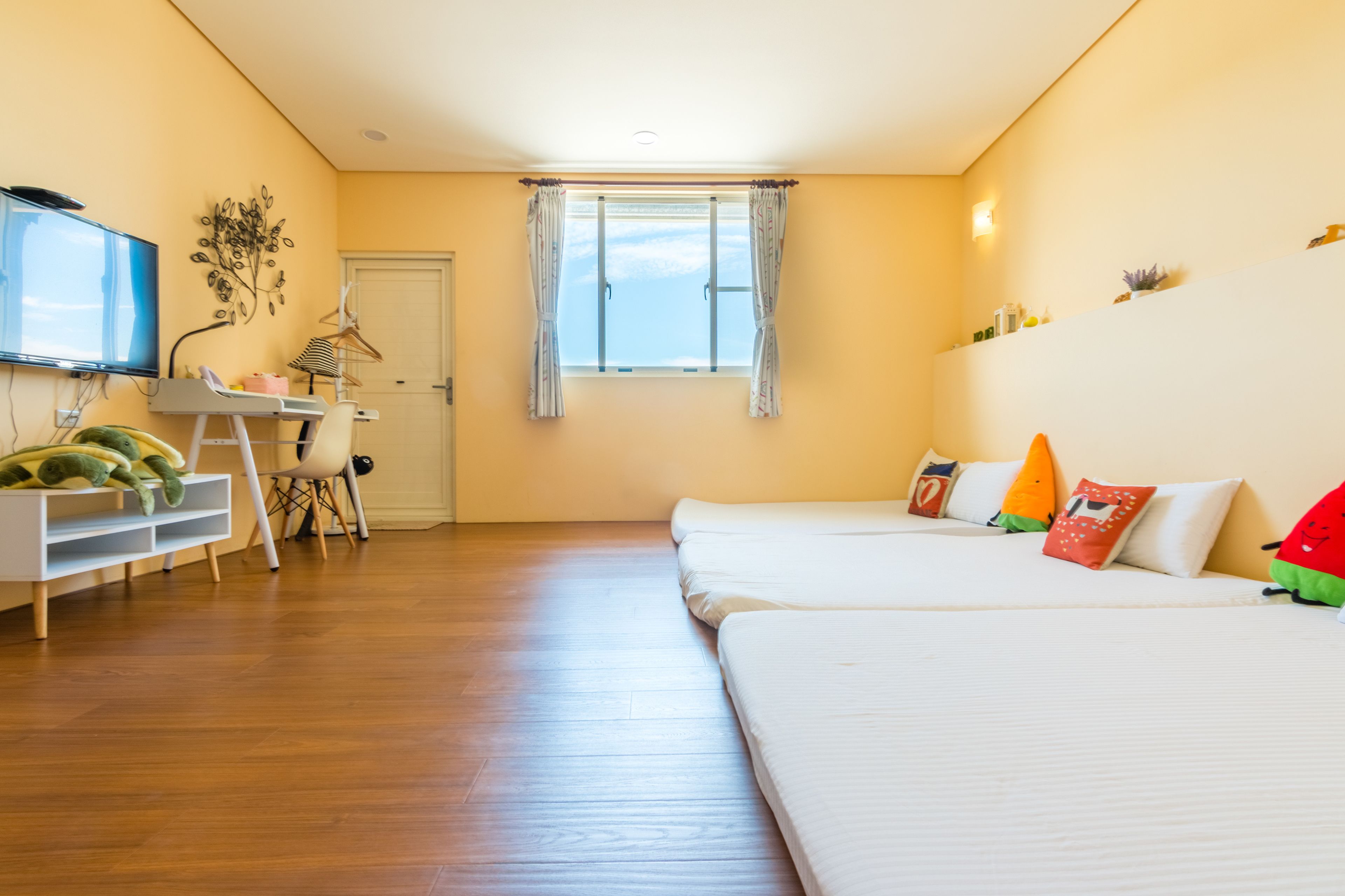 A room with a bed, a desk, a chair, a TV, and a window.