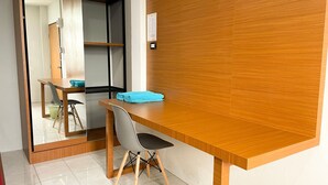 A modern room with a wooden desk, a chair, a mirror, and a shelf. - Sadudee Mansion (Surat Thani)