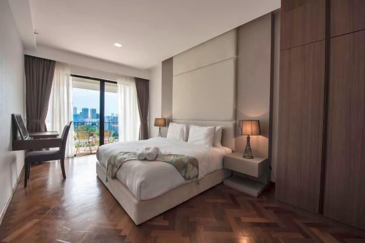 A modern hotel room with a large bed, a desk, and a view of the city.