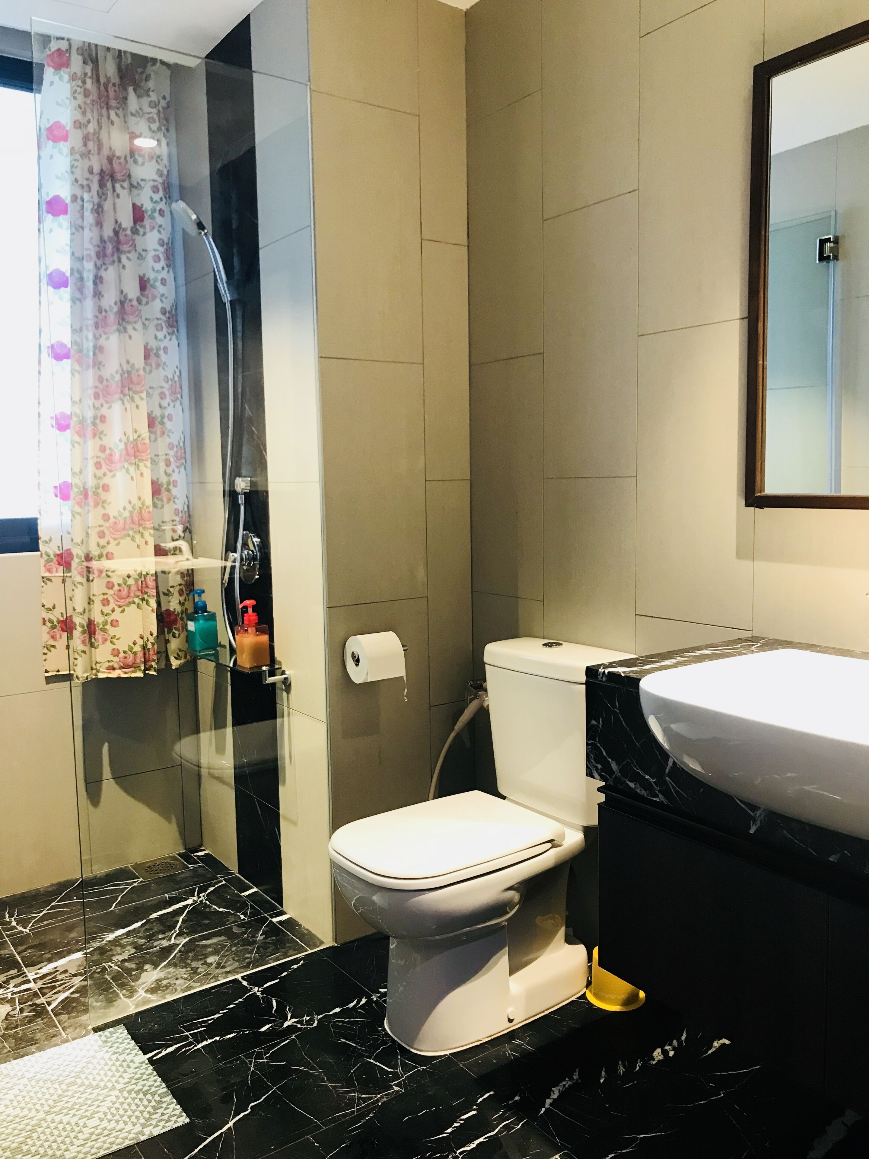 Une salle de bain équipée de toilettes, d’un lavabo, d’une douche et d’une porte en verre.