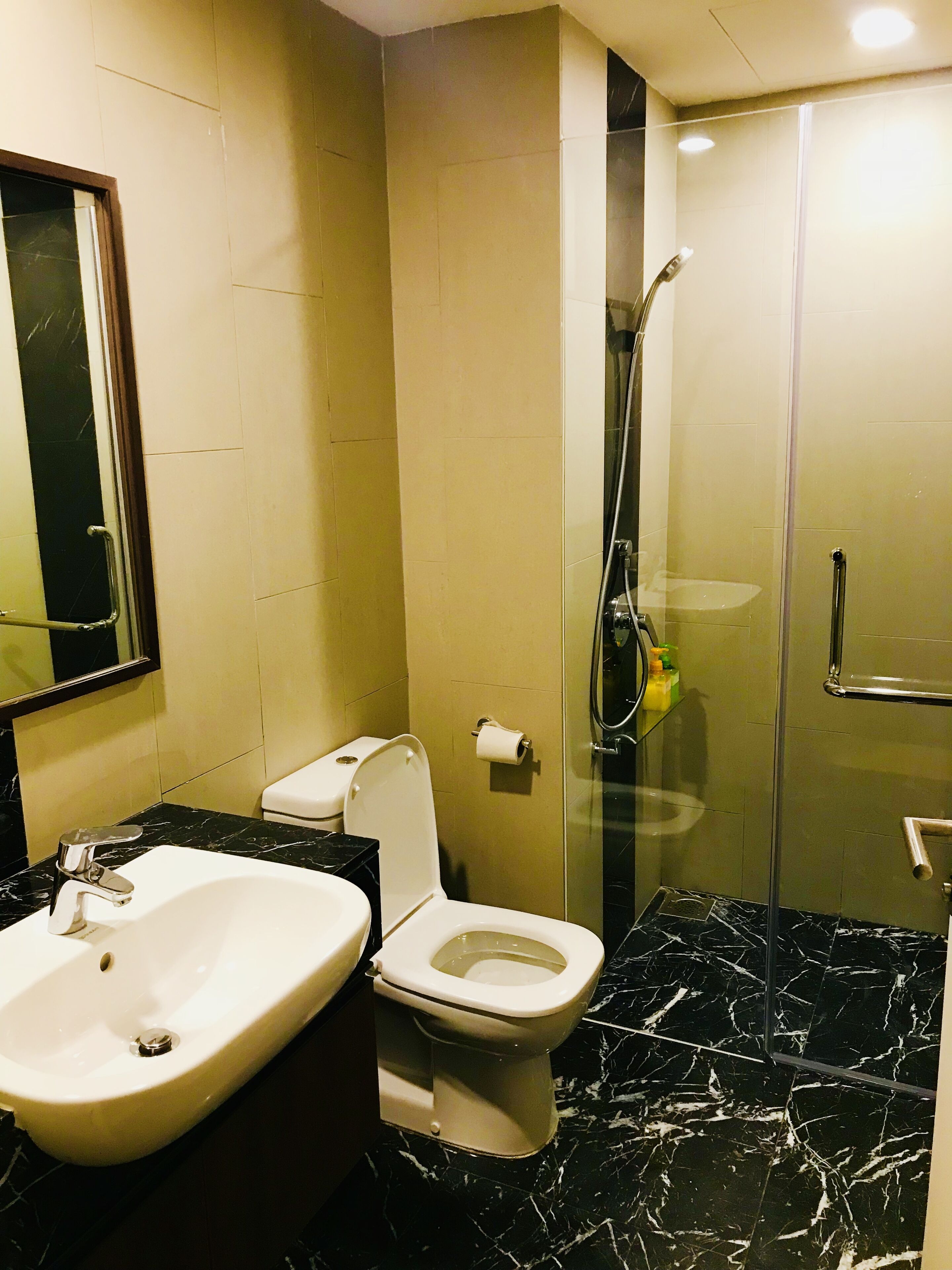 A bathroom with a white sink, toilet, and shower.
