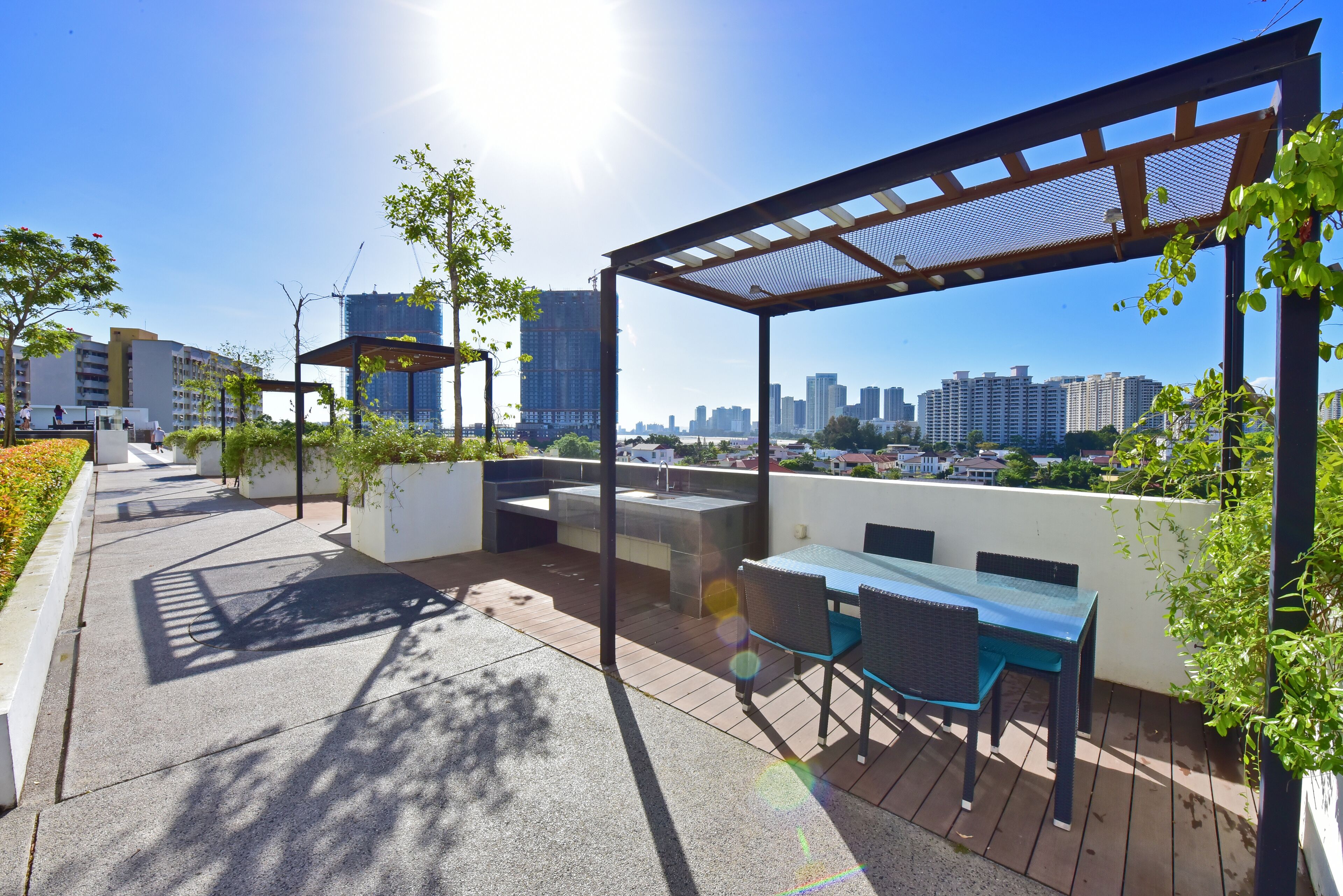 Eine Dachterrasse mit Sitzgelegenheiten im Freien, einer Pergola und Blick auf die Stadtlandschaft.