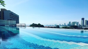 A swimming pool with clear blue water, surrounded by modern buildings and a city skyline in the background. - The Landmark by Katana (George Town)