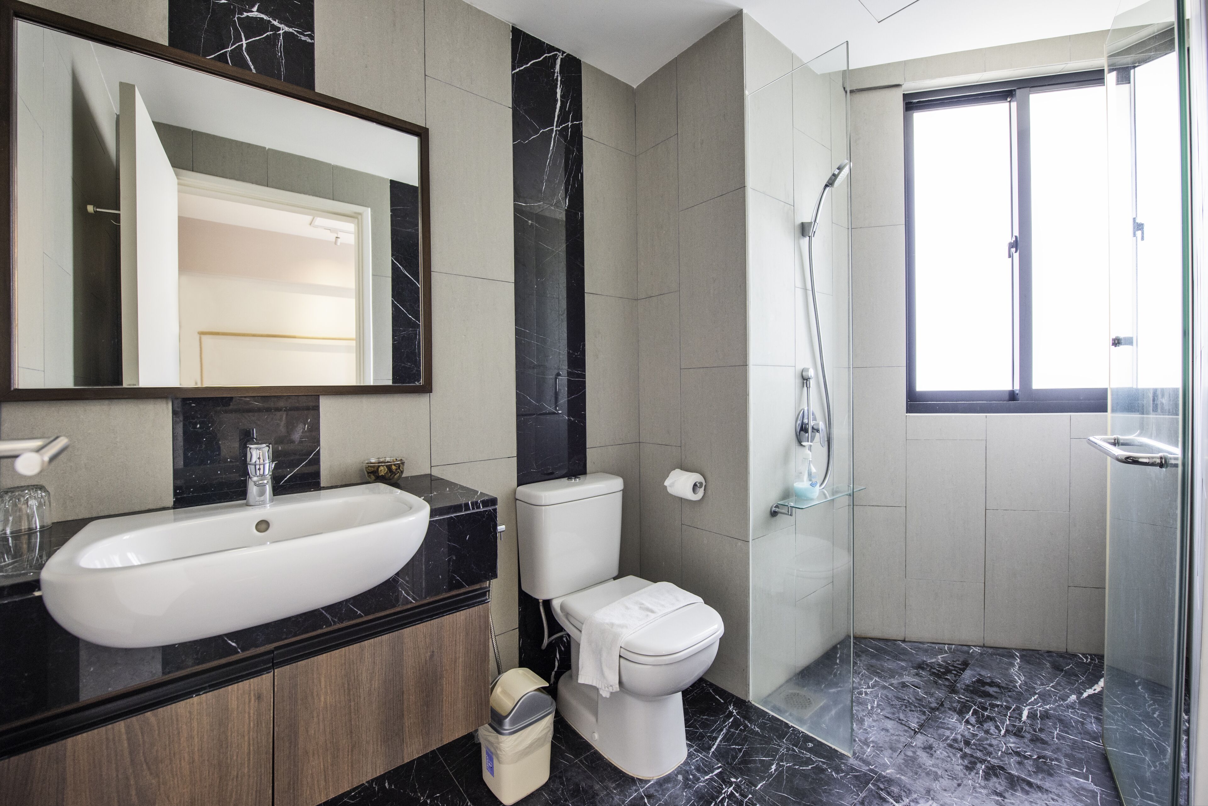 A modern bathroom with a large sink, toilet, and shower.
