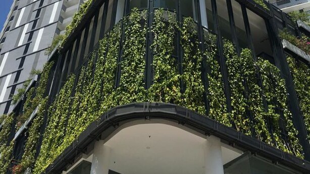 A high-rise building with a curved balcony covered in greenery. - The Landmark by Katana (George Town)