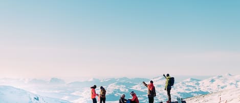 A group of people on a snowy mountain with a clear sky.
